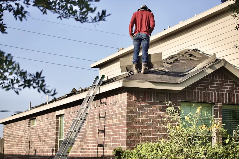 Professional roofer working on a residential roof in Listonburg